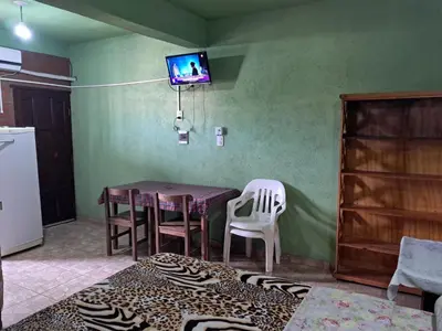 a dining room with a table and chairs and a tv at Hospedaje Pringles in Santa Rosa del Conlara