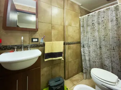 a bathroom with a sink and a toilet and a shower at Departamento con cochera y piscina centro Carlos Paz in Villa Carlos Paz
