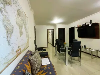 a living room with a couch and a map on the wall at Departamento con cochera y piscina centro Carlos Paz in Villa Carlos Paz