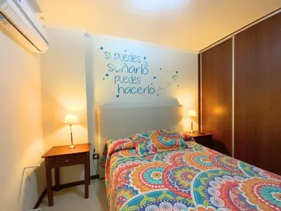 a bedroom with a bed and two tables with lamps at Departamento con cochera y piscina centro Carlos Paz in Villa Carlos Paz