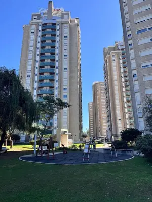 two tall buildings with a playground in a park at Alquiler del Departamento Barrio residencial in Cordoba