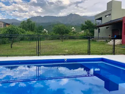 a swimming pool in front of a house with a fence at Nuestro lugar en Traslasierra in Los Hornillos