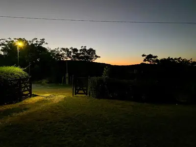 a sunset in a field with a fence and a street light at Nuestro lugar en Traslasierra in Los Hornillos