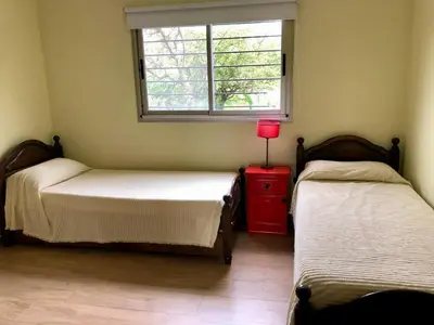 two beds in a room with a window and a red dresser at Nuestro lugar en Traslasierra in Los Hornillos
