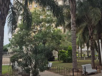 a group of palm trees in a park with a fence at Departamento en Complejo Villa Sol in Cordoba
