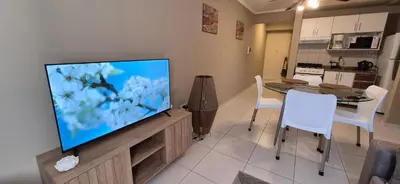 a living room with a flat screen tv on a entertainment center at Departamento en Complejo Villa Sol in Cordoba