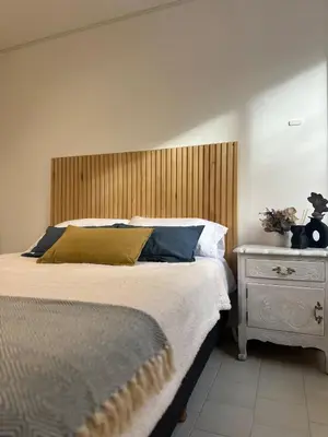 a bedroom with a large bed with a wooden headboard at Monoambiente en el centro de Córdoba in Cordoba