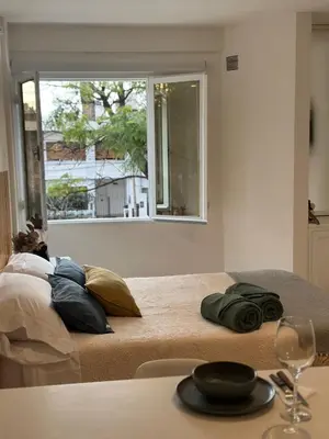 a person laying on a bed in a room with a window at Monoambiente en el centro de Córdoba in Cordoba