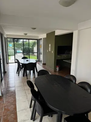 a dining room with a black table and chairs at Departamento Carlos Paz in Villa Carlos Paz