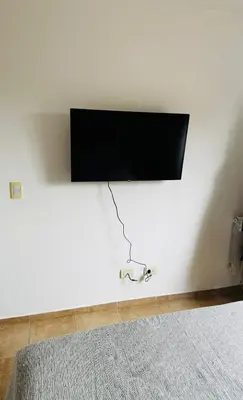 a flat screen tv hanging on a white wall at Departamento Carlos Paz in Villa Carlos Paz