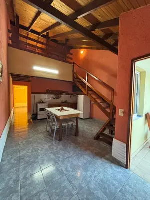 a kitchen with a table and a staircase in a room at Apart Morena in Villa Rumipal