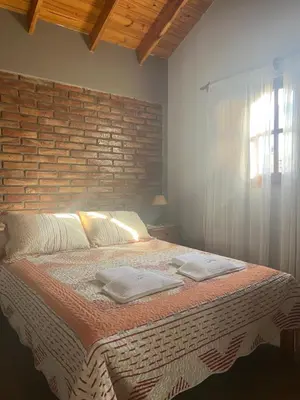 a bedroom with a large bed with two towels on it at cabañas Samay-Piskho in Santa Rosa de Calamuchita