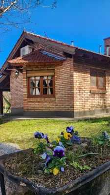 a flower bed in front of a house at cabañas Samay-Piskho in Santa Rosa de Calamuchita