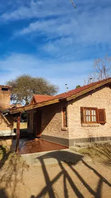 a brick house with a driveway in front of it at cabañas Samay-Piskho in Santa Rosa de Calamuchita