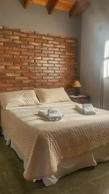 a bedroom with a large bed with two towels on it at cabañas Samay-Piskho in Santa Rosa de Calamuchita
