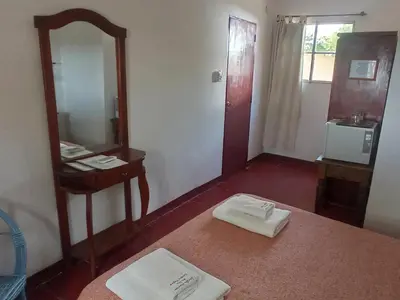 a bathroom with a mirror and a table with two towels at Estancia Santa María de las Casas Viejas in Mina Clavero
