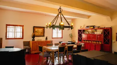 a dining room with a table and chairs and a chandelier at Estancia Santa María de las Casas Viejas in Mina Clavero