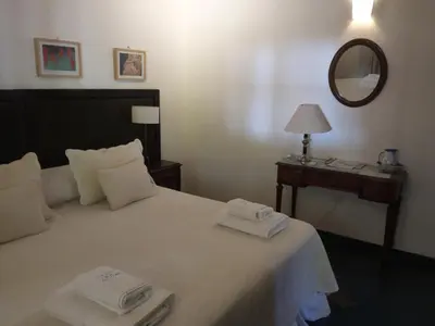 a bedroom with a bed with two towels on it at Estancia Santa María de las Casas Viejas in Mina Clavero