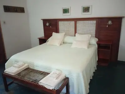 a bedroom with a large bed with two towels on it at Estancia Santa María de las Casas Viejas in Mina Clavero