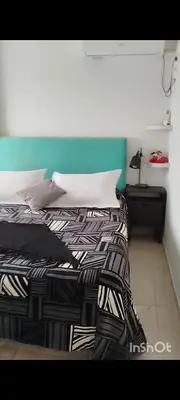 a bed with a black and white comforter in a room at Departamento 1 dormitorio in Cordoba