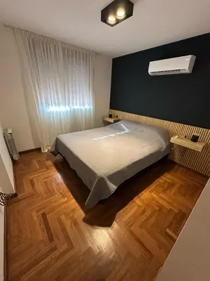 a bedroom with a bed and a wooden floor at Modern apartment - Nueva Córdoba in Cordoba