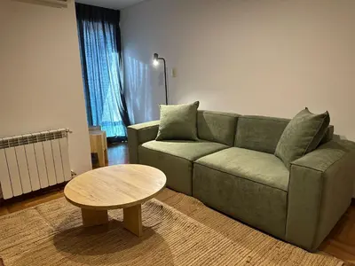 a living room with a green couch and a table at Modern apartment - Nueva Córdoba in Cordoba
