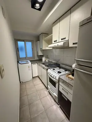 a kitchen with white cabinets and a stove and refrigerator at Modern apartment - Nueva Córdoba in Cordoba