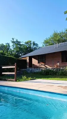 a house with a swimming pool in front of a house at la riviere in Alta Gracia