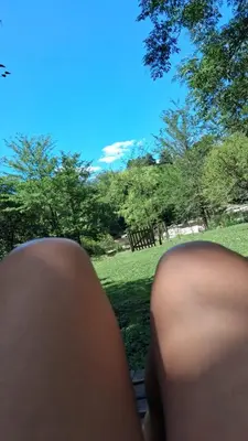 a person sitting on a bench looking at a park at la riviere in Alta Gracia