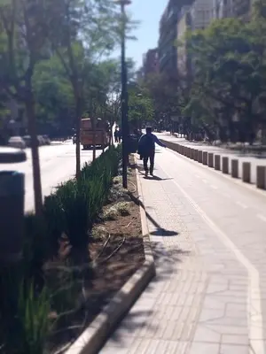 a person walking a dog down a city street at Chacabuco 275 By Suviex in Cordoba