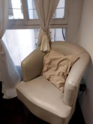 a white chair with a pillow on it in front of a window at Chacabuco 275 By Suviex in Cordoba