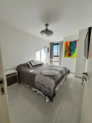 a bedroom with a large bed in a white room at Avellaneda Homestay in Cordoba