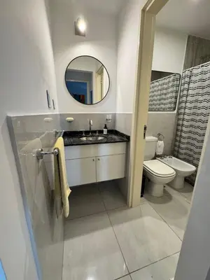 a bathroom with a sink and a toilet and a mirror at Avellaneda Homestay in Cordoba