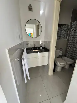 a bathroom with a sink and a toilet and a mirror at Avellaneda Homestay in Cordoba