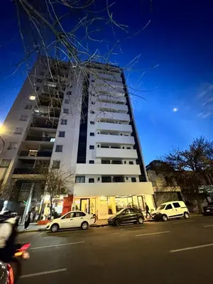 a tall white building with cars parked in front of it at Avellaneda Homestay in Cordoba