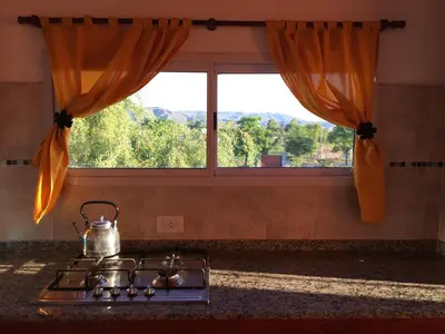 a tea kettle sitting on a stove in front of a window at Complejo BIALET MASSE in Bialet Massé