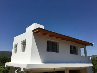 a white house with a red roof at Complejo BIALET MASSE in Bialet Massé