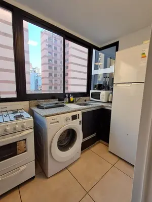 a kitchen with a washing machine and a refrigerator at Chacabuco 400 B Nueva Cordoba in Cordoba
