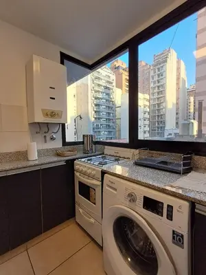 a kitchen with a washing machine and a window at Chacabuco 400 B Nueva Cordoba in Cordoba
