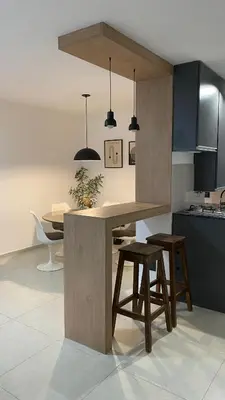 a kitchen with a counter with two stools and a table at Departamento Plaza Colón in Cordoba