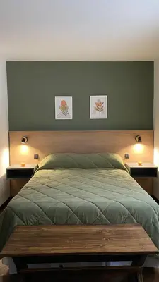 a bedroom with a bed with two lights on the wall at Departamento Plaza Colón in Cordoba