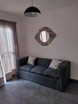 a blue couch in a living room with a mirror at Tierra Madre in Santa Rosa de Calamuchita