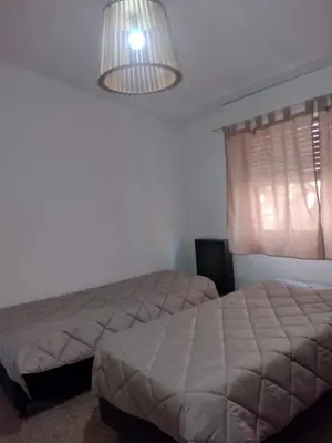 a bedroom with two beds and a lamp at Tierra Madre in Santa Rosa de Calamuchita