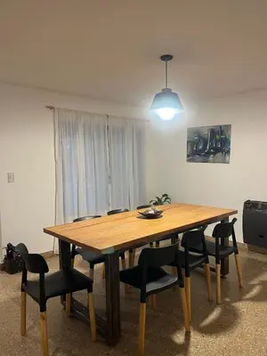 a wooden table and chairs in a room at Tierra Madre in Santa Rosa de Calamuchita