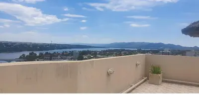 a balcony with a view of a river and mountains at Edificio Melos Villa Carlos Paz in Villa Carlos Paz
