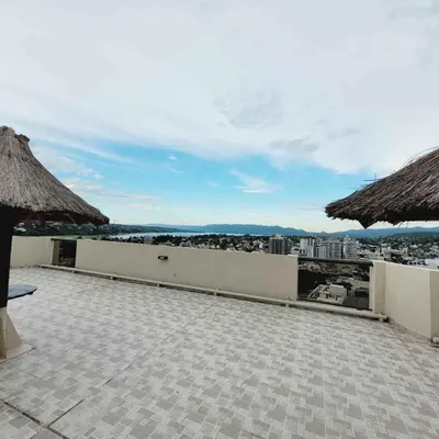 a patio with umbrellas and a view of a city at Edificio Melos Villa Carlos Paz in Villa Carlos Paz