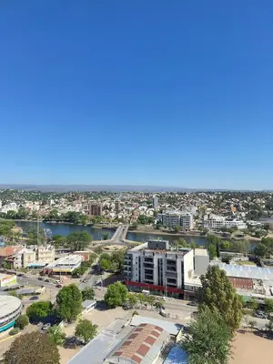 an aerial view of a city with a river and buildings at Edificio Melos Villa Carlos Paz in Villa Carlos Paz