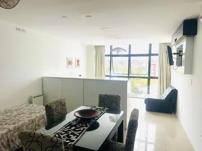 a room with a bed and a table and chairs at Edificio Melos Villa Carlos Paz in Villa Carlos Paz