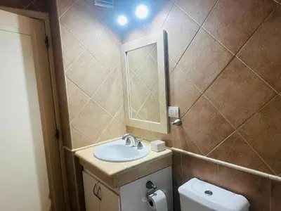 a bathroom with a sink and a mirror and a toilet at Edificio Melos Villa Carlos Paz in Villa Carlos Paz