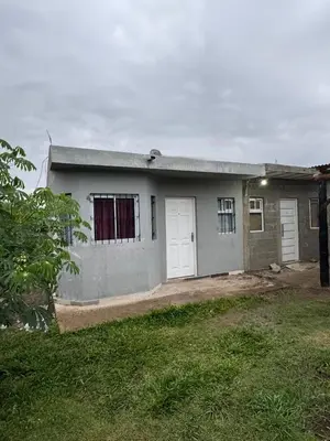 a house with two white doors and a yard at Cabañas Antonia in San Javier